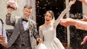 A bride and groom are throwing confetti at each other.